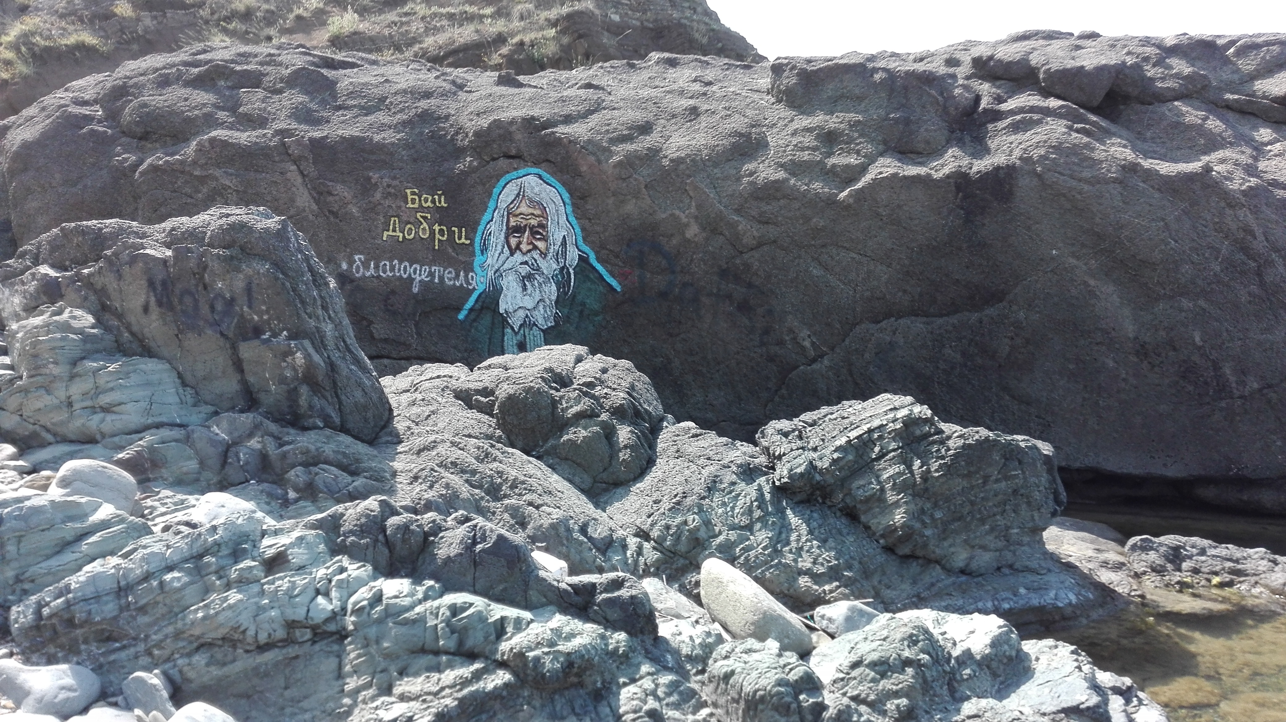 Ликът на Дядо Добри гледа от морските скали 